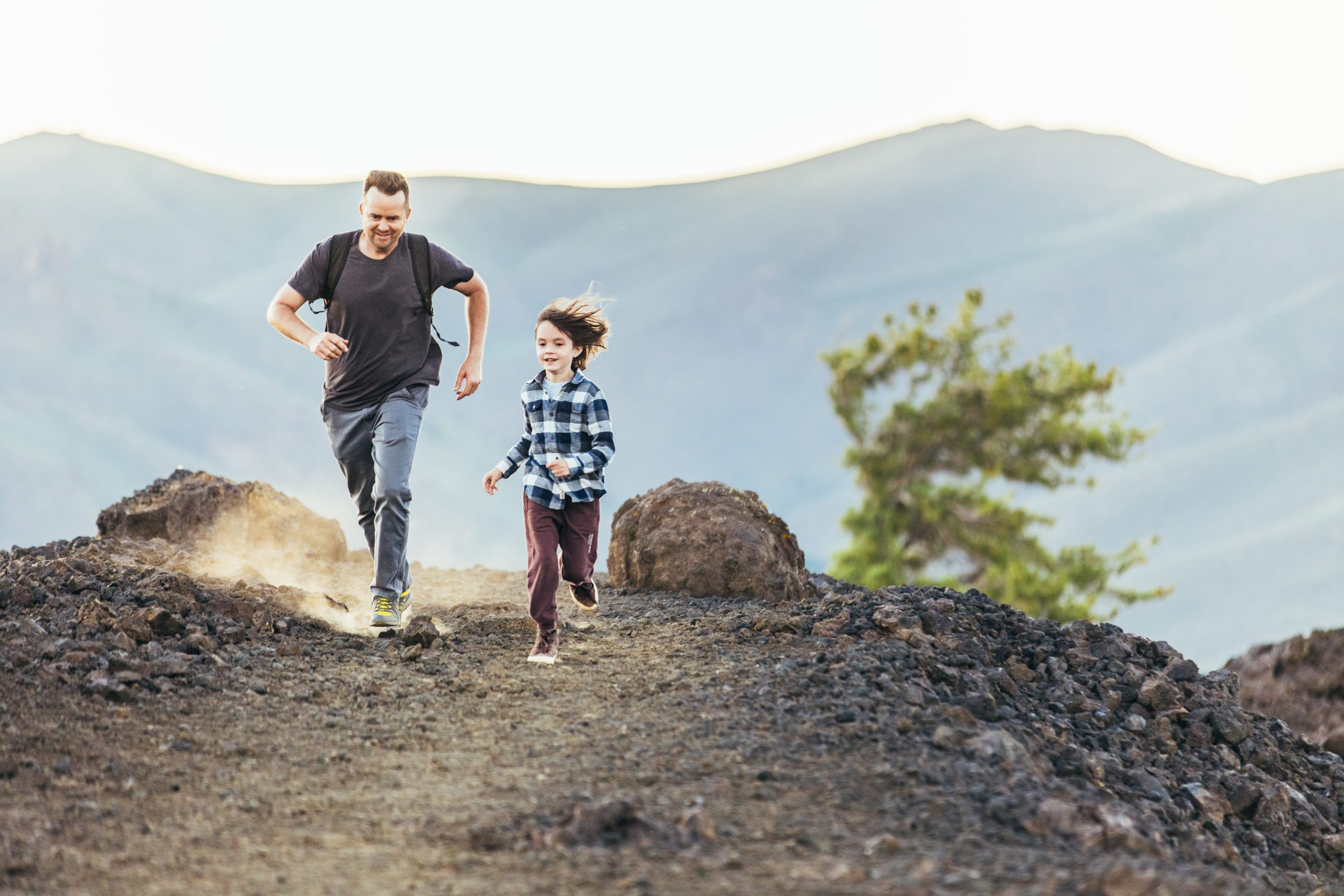 A man and his son running along a rocky trail at Craters of the Moon National Monument & Preserve.